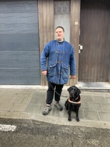 Telma assise a côté de son bénéficiaire, Christian, vêtu d'une grande chemise bleue