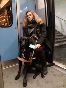 Maki est assis avec sa bénéficiaire, sur un strappontin du metro