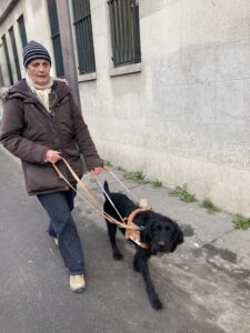 SAtine guide sa bénéficiaire, sur un trottoir
