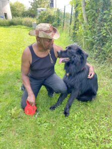 Shadow est assis a côté d'un homme avec un chapeau
