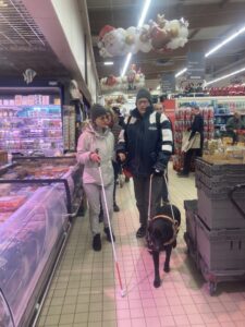 Tia guide son bénéficiaire dans un supermarché