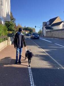 Topaze guide son bénéficiaire sur le trottoir