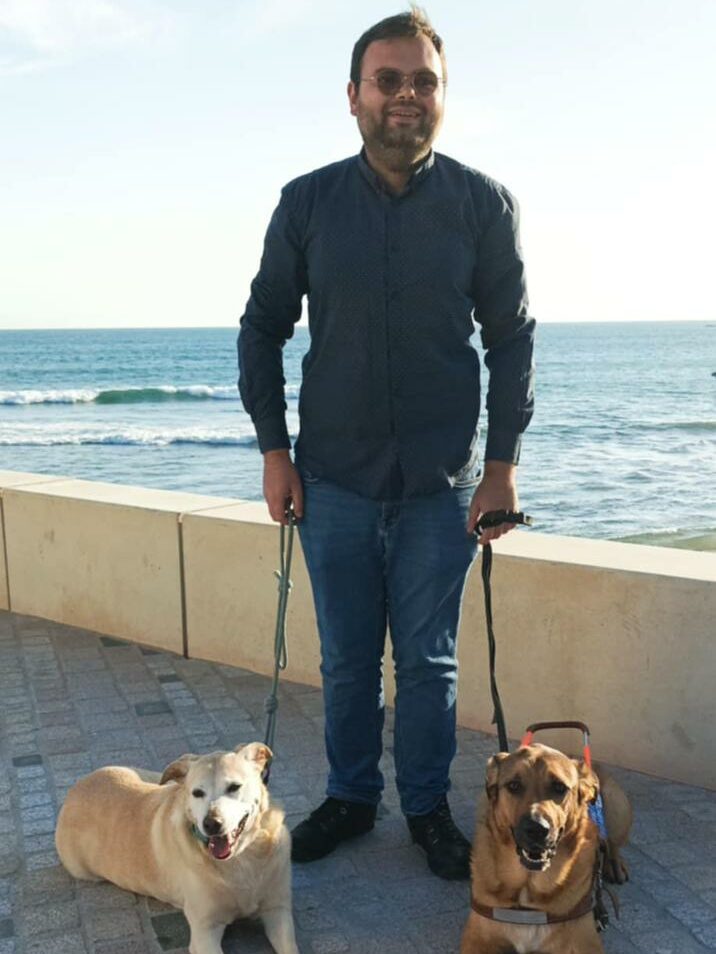 Lucas pose debout sur un fond de mer, avec à chacune de ses mains, une laisse vers Ajitée et Buddha